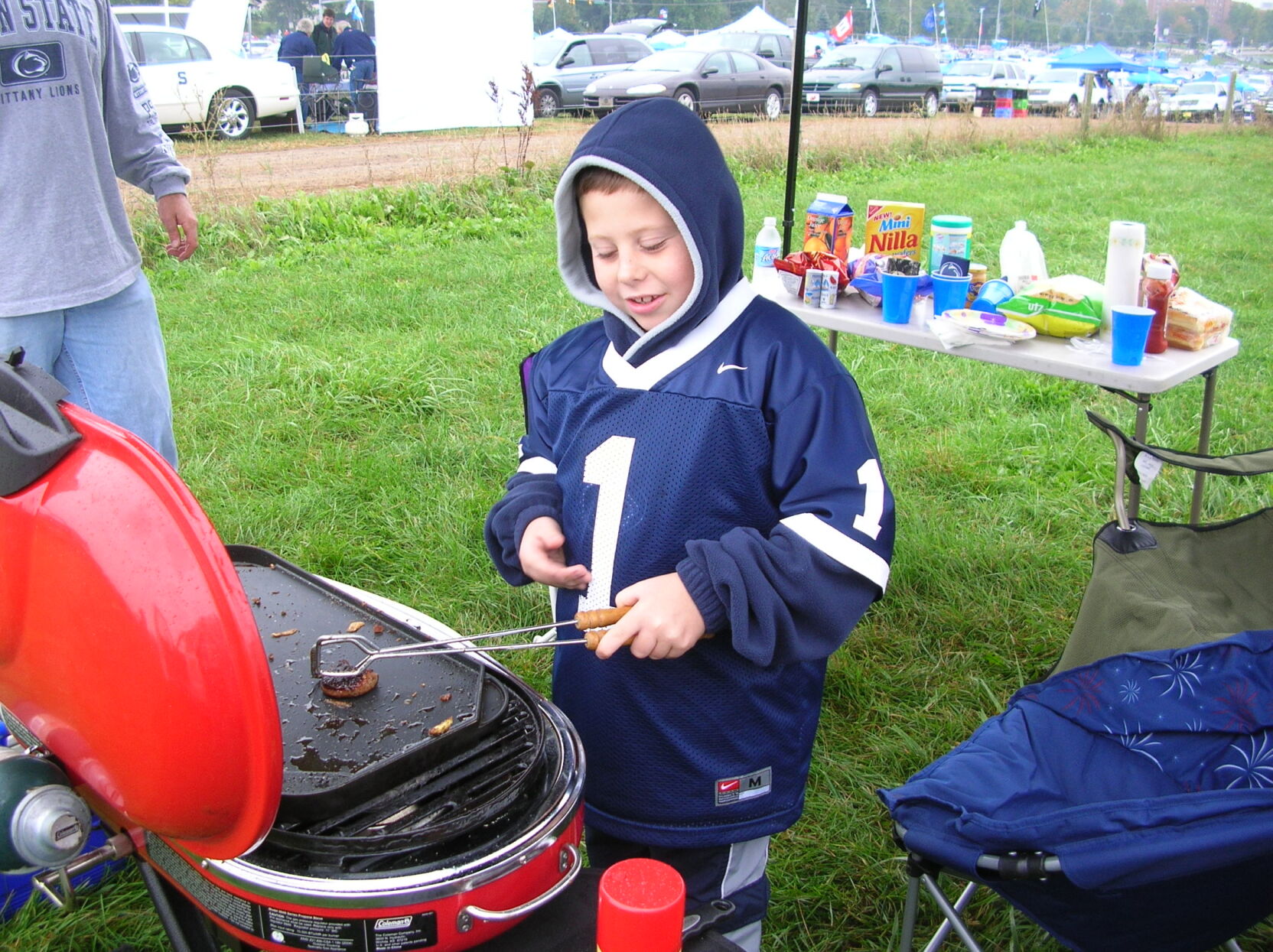 Ben grills as a youth at a tailgate